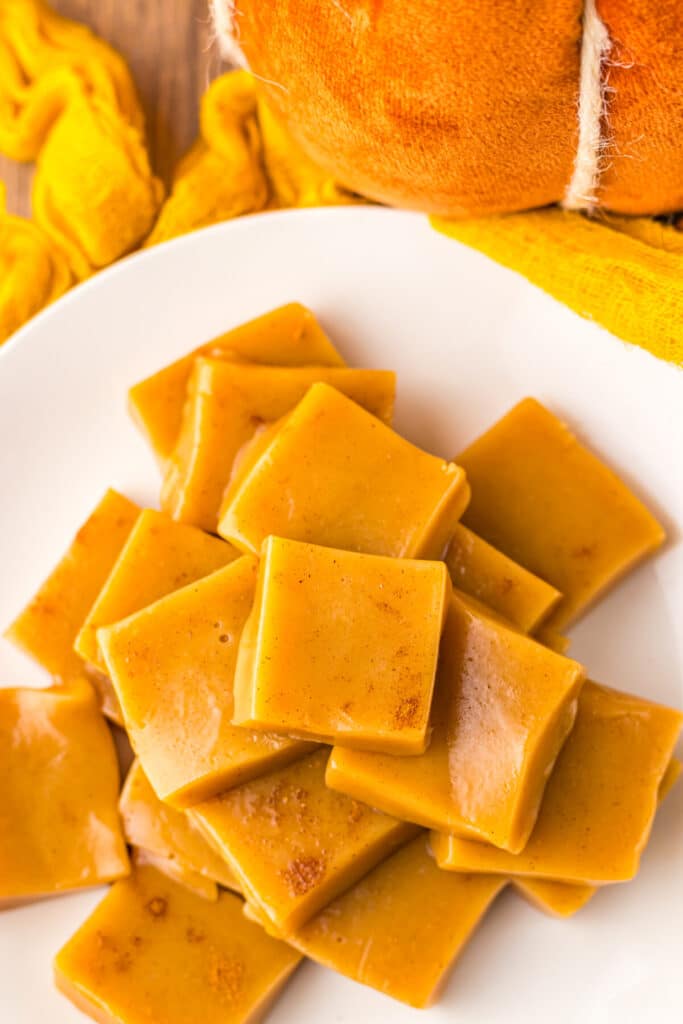 Close-up of golden pumpkin spice caramels with pumpkins in the background