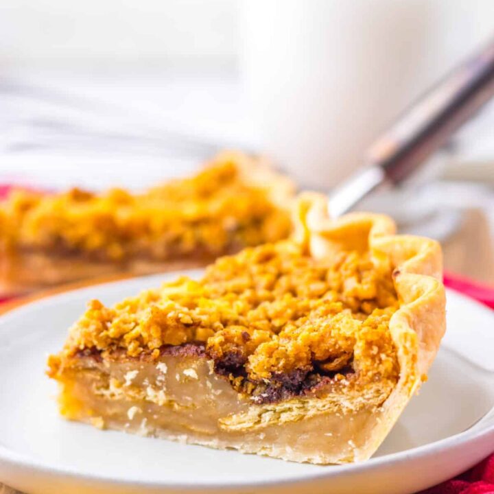 Slice of mock apple pie served on a plate with fork and red napkin in background