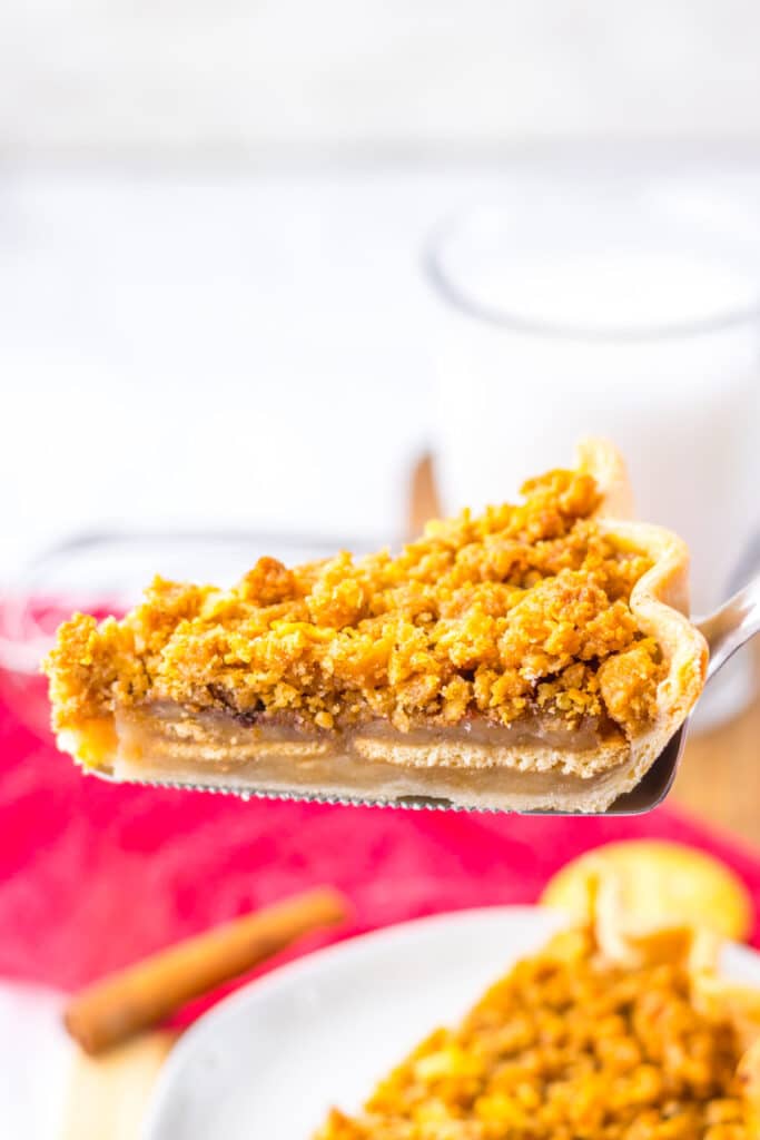 Slice of mock apple pie served on a plate with fork and red napkin in background