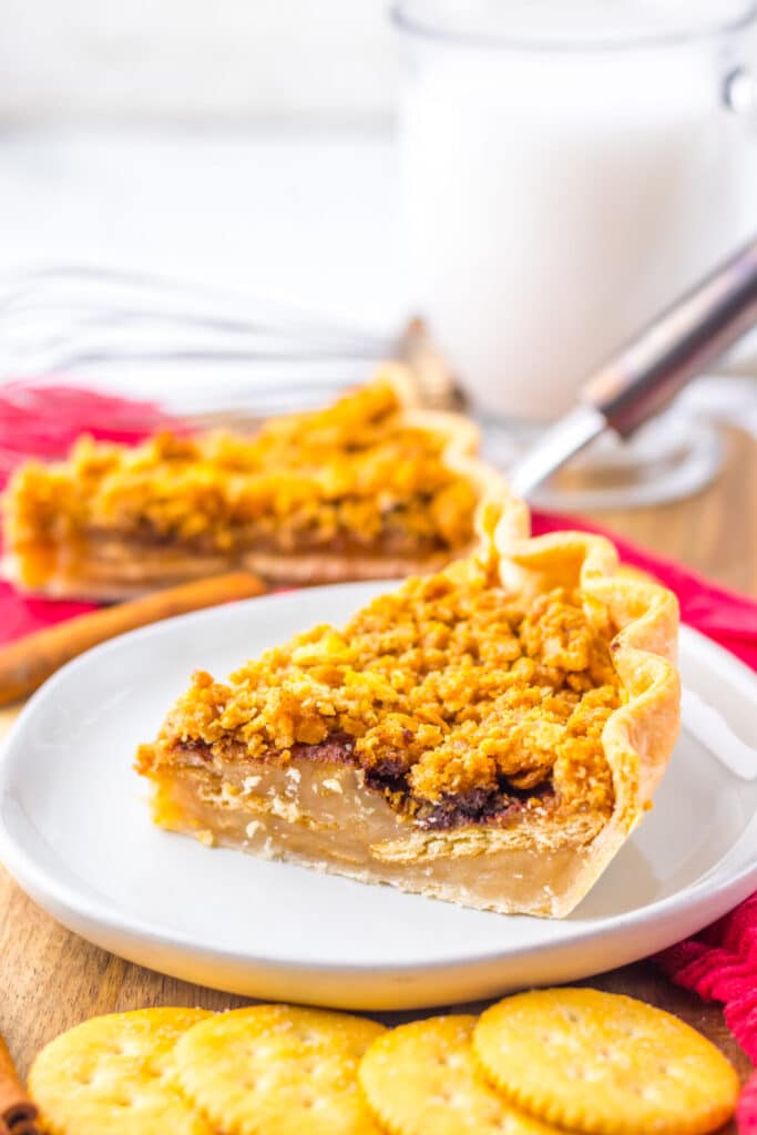Slice of mock apple pie served on a plate with fork and red napkin in background