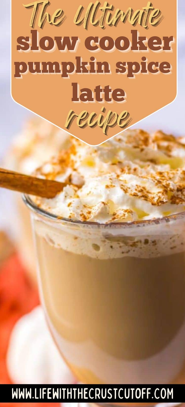Pumpkin spice latte in a clear glass topped with whipped cream and sprinkled cinnamon.