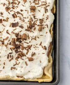 Easy French silk slab pie topped with whipped cream and chocolate curls
