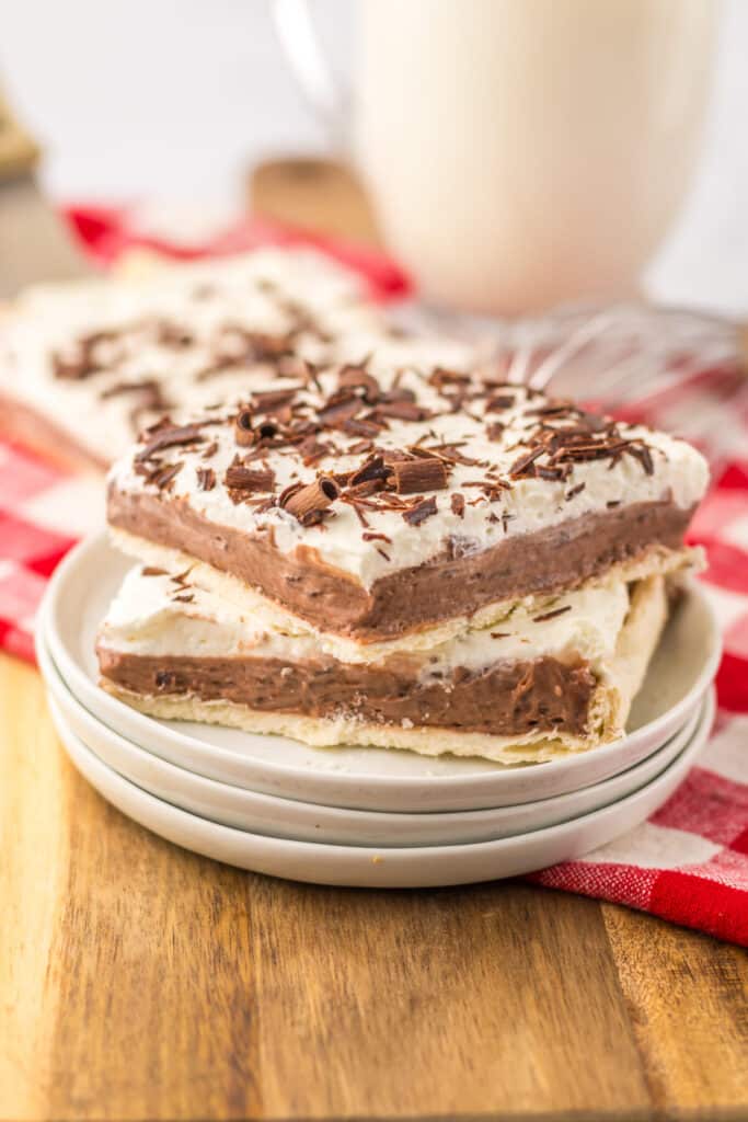 Slice of French silk slab pie with whipped cream and chocolate shavings on plate