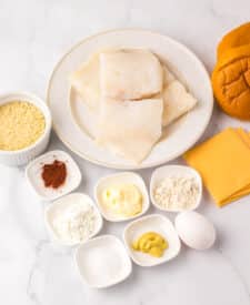 Ingredients for homemade Filet-O-Fish including buns, cheese, tartar sauce, and breaded fish.