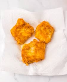 Plate of breaded fish fillets cooked golden brown.