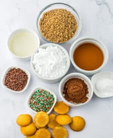 Ingredients for bourbon balls measured out in bowls, including wafers, pecans, cocoa, and bourbon.