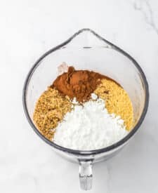 Mixing bowl with crushed vanilla wafers, powdered sugar, cocoa powder, and pecans.