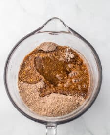 Wet and dry ingredients for bourbon balls combined in a mixing bowl.
