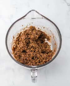Wet and dry ingredients for bourbon balls combined in a mixing bowl.