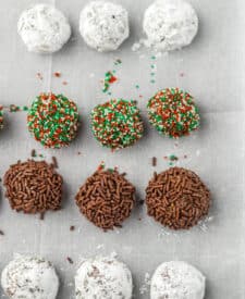 Bourbon ball mixture rolled into small balls on a parchment-lined tray.