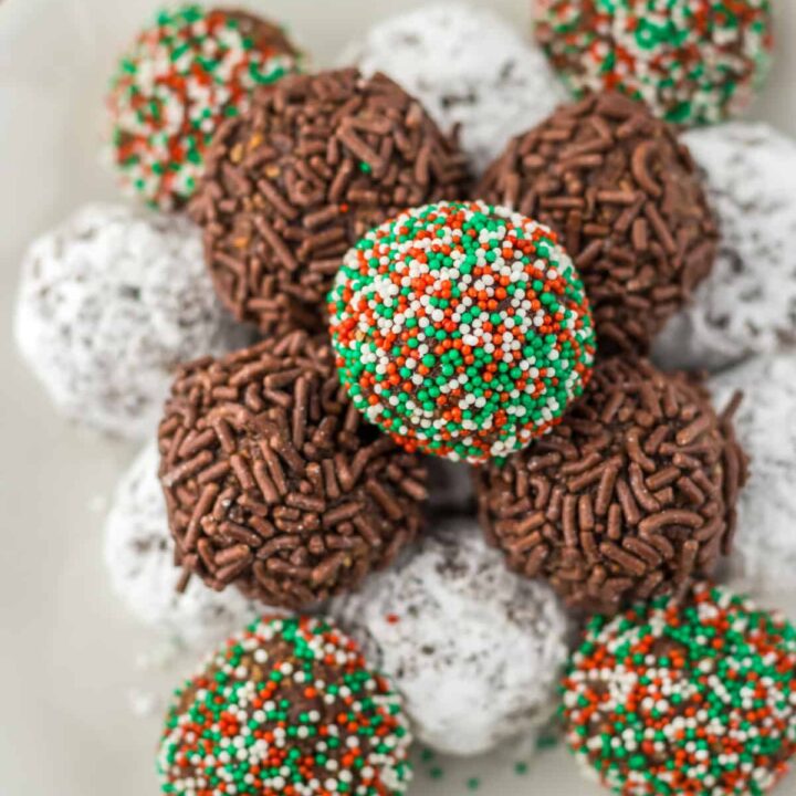 Overhead view of bourbon balls arranged on a tray with different coatings.