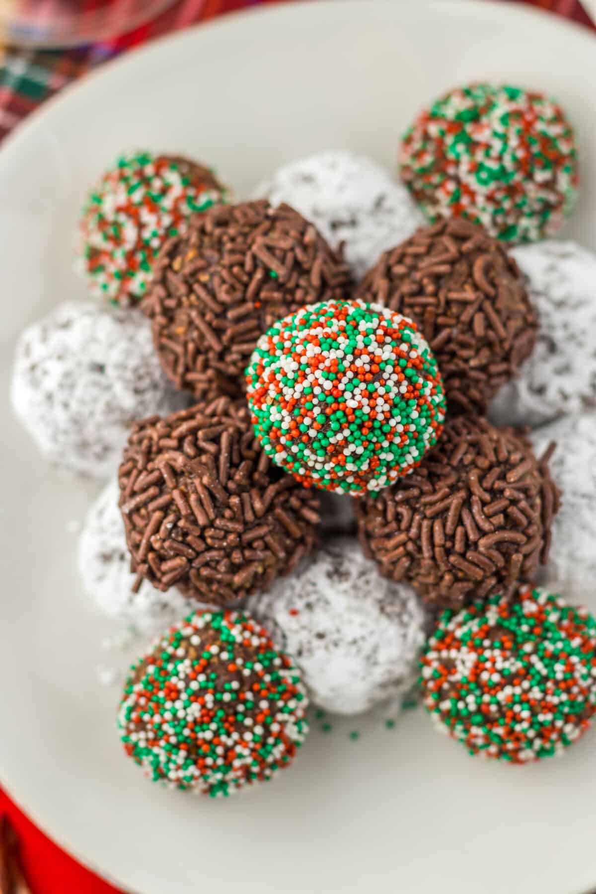 Overhead view of bourbon balls arranged on a tray with different coatings.