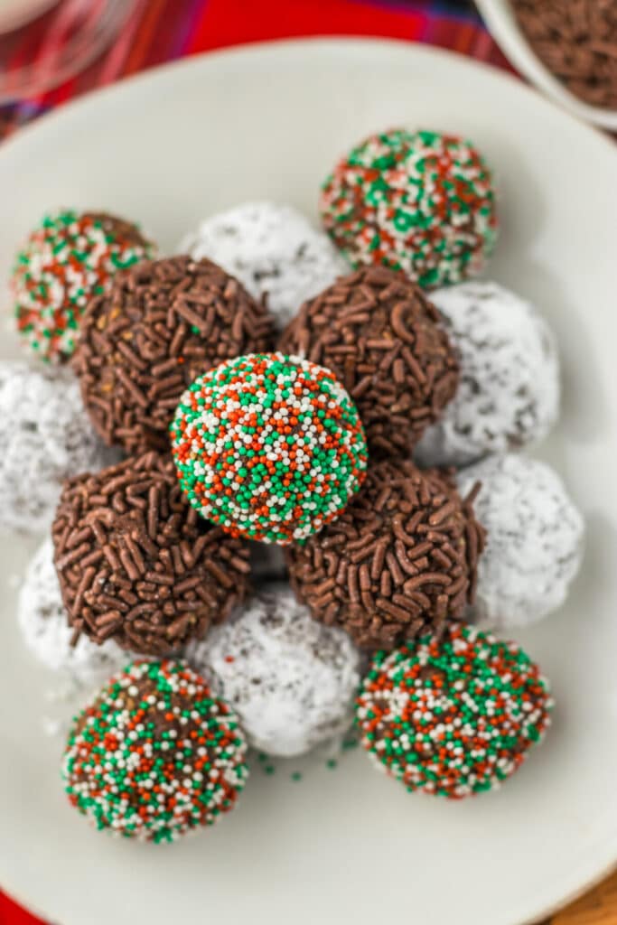 Overhead view of bourbon balls arranged on a tray with different coatings.