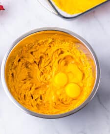 Mixing bowl with softened cream cheese and pumpkin puree.