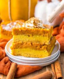 11. Pumpkin gooey butter bar slice stacked with layers of crust and pumpkin filling visible.