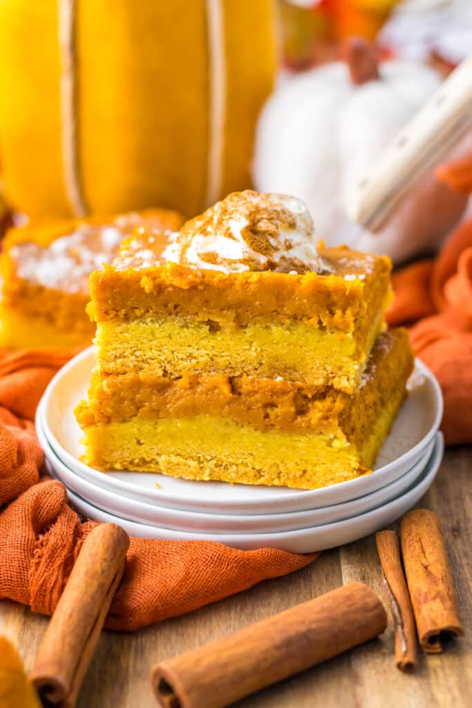11. Pumpkin gooey butter bar slice stacked with layers of crust and pumpkin filling visible.
