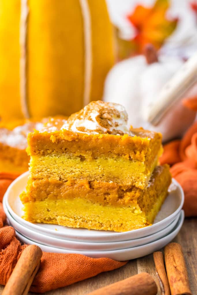 11. Pumpkin gooey butter bar slice stacked with layers of crust and pumpkin filling visible.