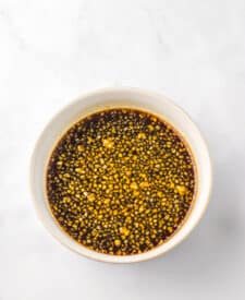 Honey garlic chicken wings with sticky sauce in a white bowl.