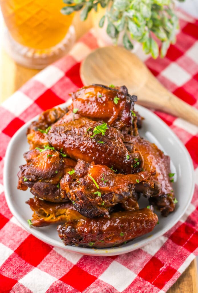 Overhead view of sticky honey garlic wings in a white serving bowl.