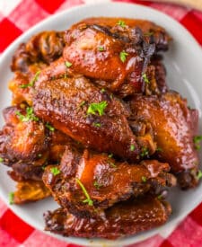 Overhead view of sticky honey garlic wings in a white serving bowl.