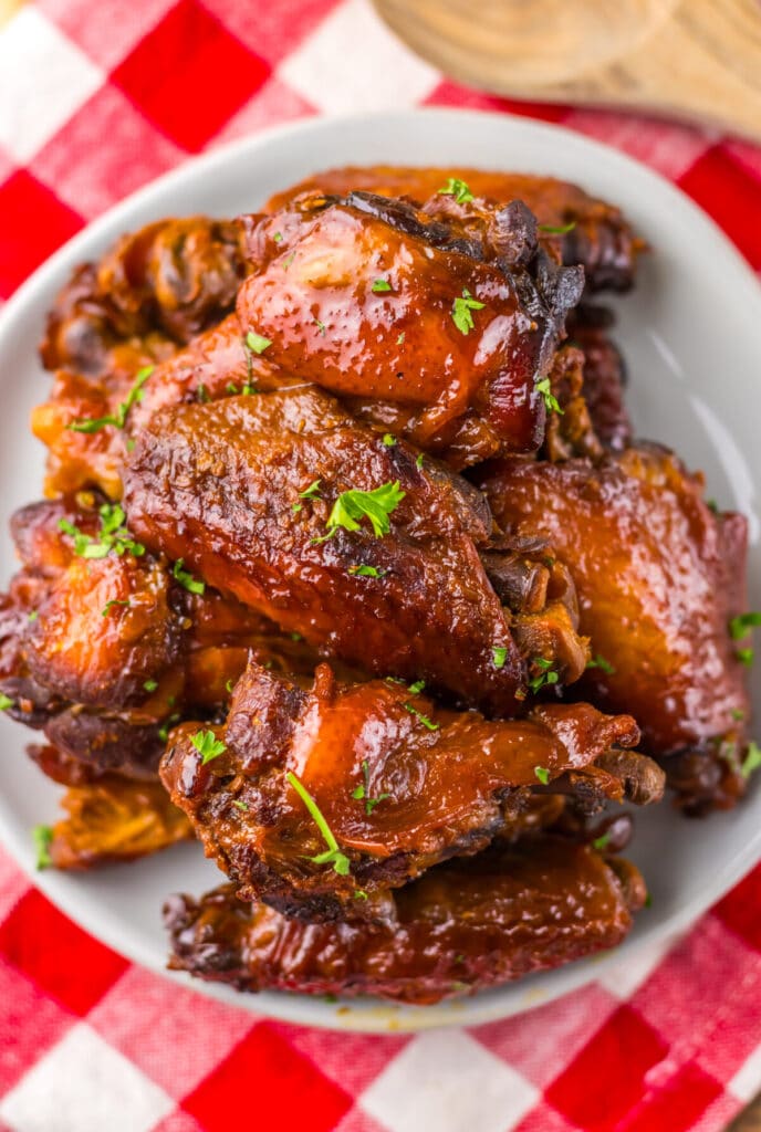 Overhead view of sticky honey garlic wings in a white serving bowl.
