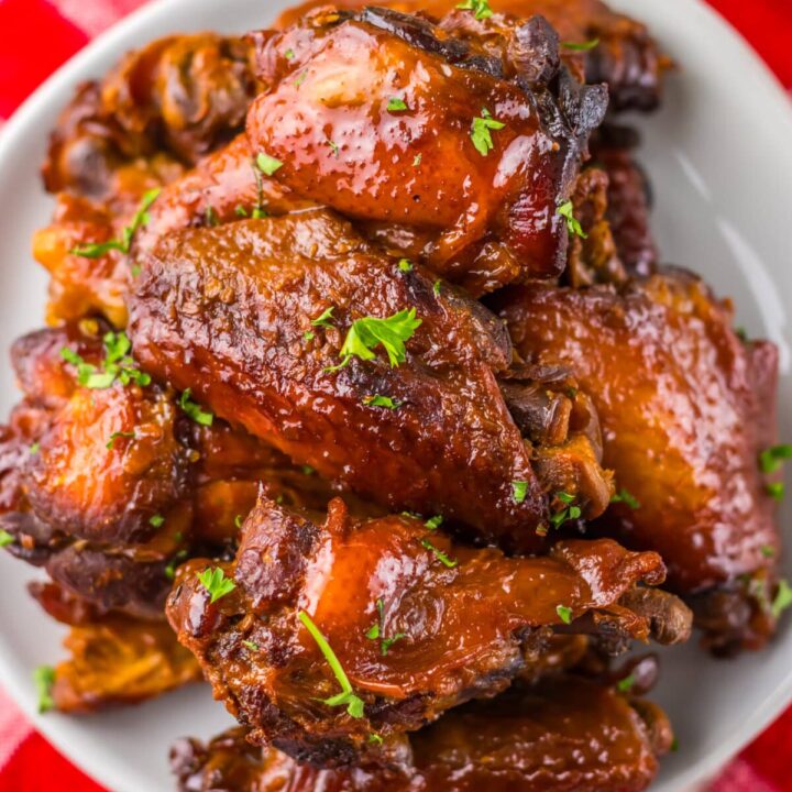 Overhead view of sticky honey garlic wings in a white serving bowl.