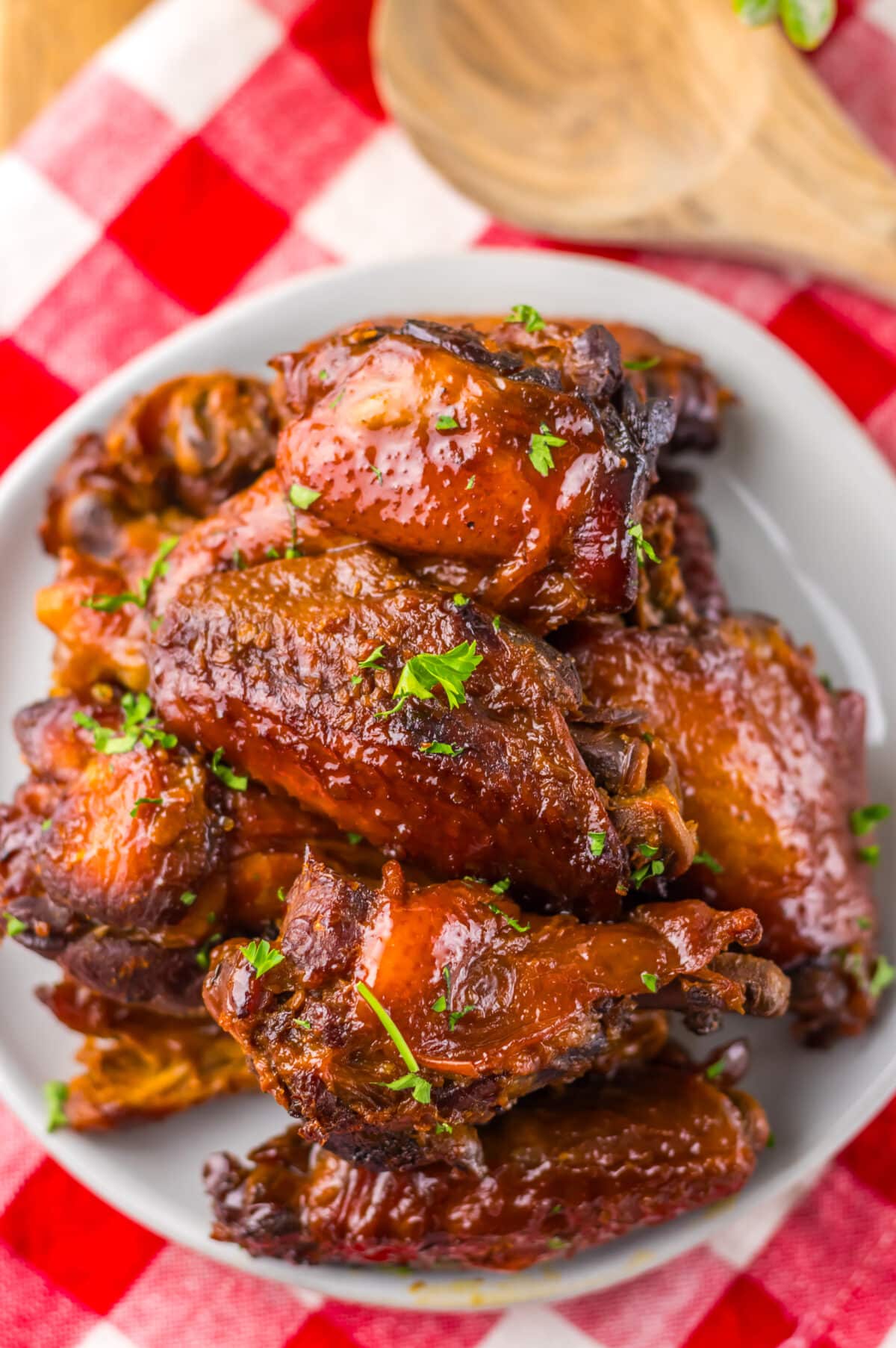 Overhead view of sticky honey garlic wings in a white serving bowl.