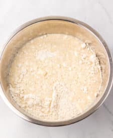 Mixing bowl with flour, yeast, sugar, and salt for slow cooker bread.