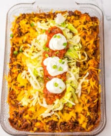 Close-up of taco bubble up bake garnished with sour cream and diced tomatoes.
