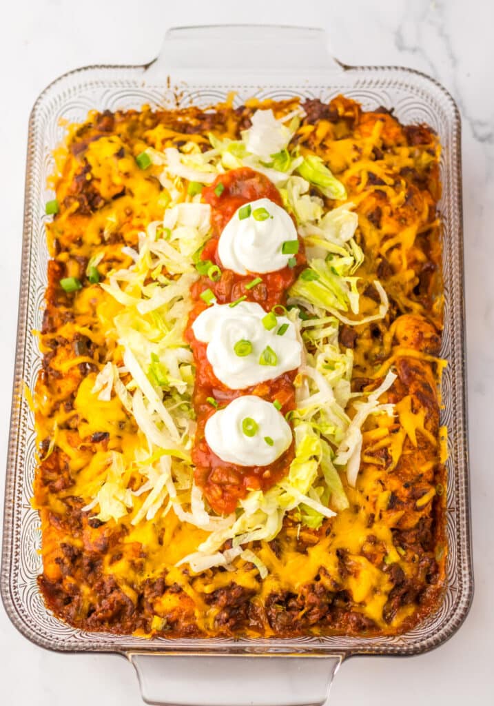 Close-up of taco bubble up bake garnished with sour cream and diced tomatoes.