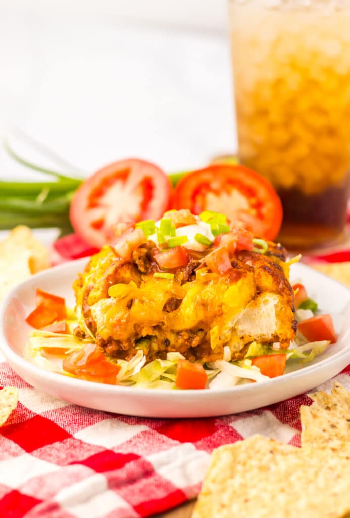 Taco bubble up casserole served on a white plate with fresh toppings.