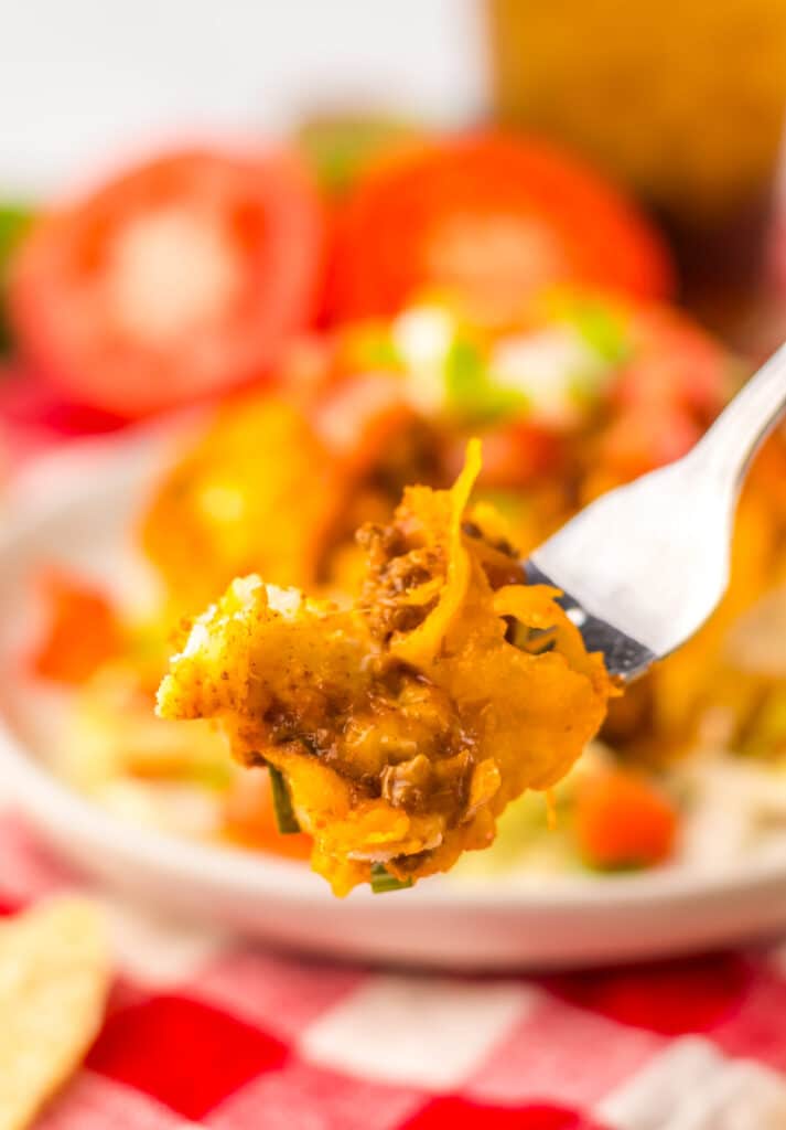 Fork lifting a cheesy bite of taco bubble up bake.