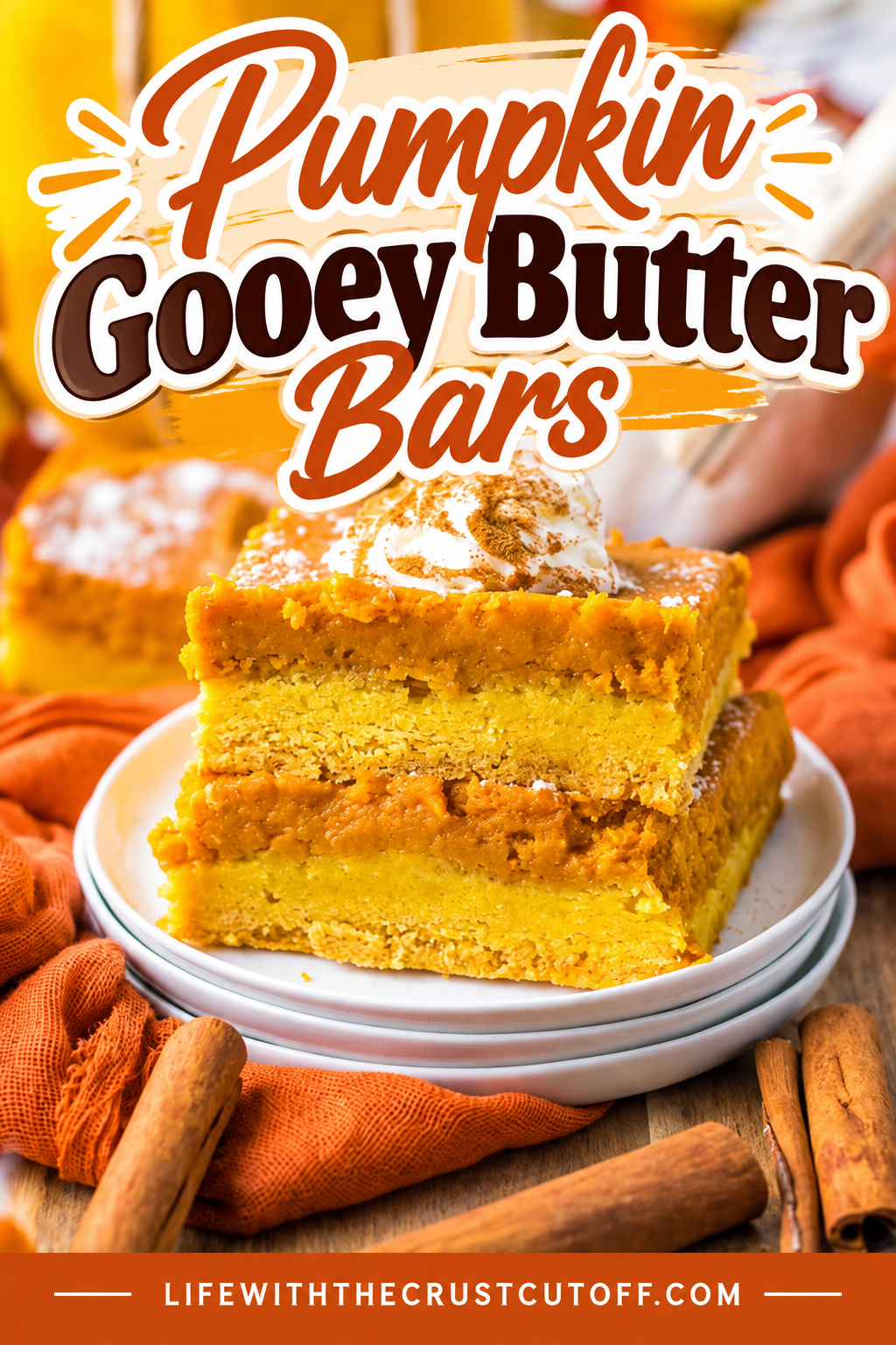 Pumpkin Gooey Butter Bars topped with whipped cream and cinnamon and served with pumpkins and cinnamon sticks.