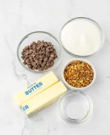 Ingredients for English toffee laid out in bowls—brown sugar, butter, chocolate chips, almonds, and vanilla.