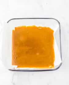 Golden sheet of classic English toffee cooling on parchment paper before adding chocolate and nuts