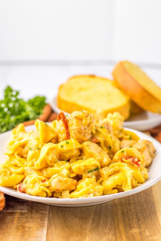 Creamy Marry Me Chicken Tortellini served in a white bowl topped with chopped parsley