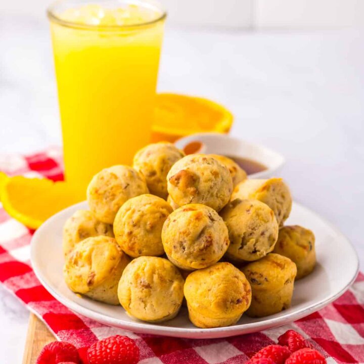 Plate of McGriddle bites beside orange juice on white background