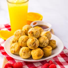 Plate of McGriddle bites beside orange juice on white background