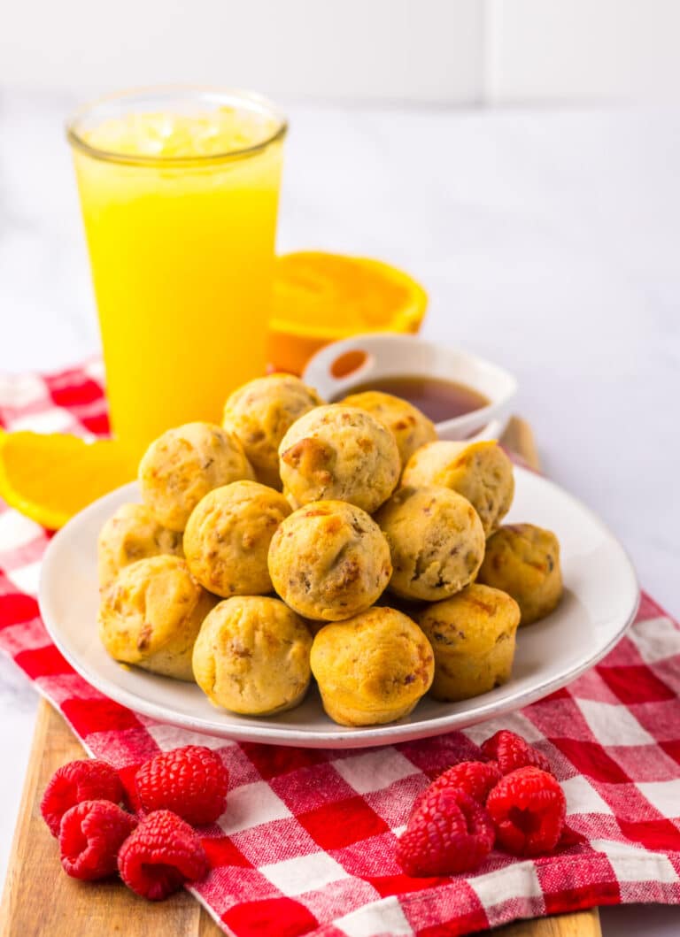 Plate of McGriddle bites beside orange juice on white background