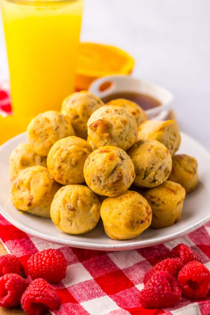 Plate of McGriddle bites beside orange juice on white background