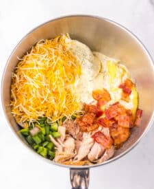 Mixing the creamy ranch chicken filling in the slow cooker with shredded chicken, bacon, and cheese.