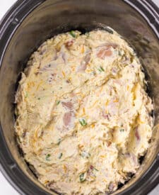 Overhead view of the creamy chicken bacon ranch mixture in the slow cooker before topping.