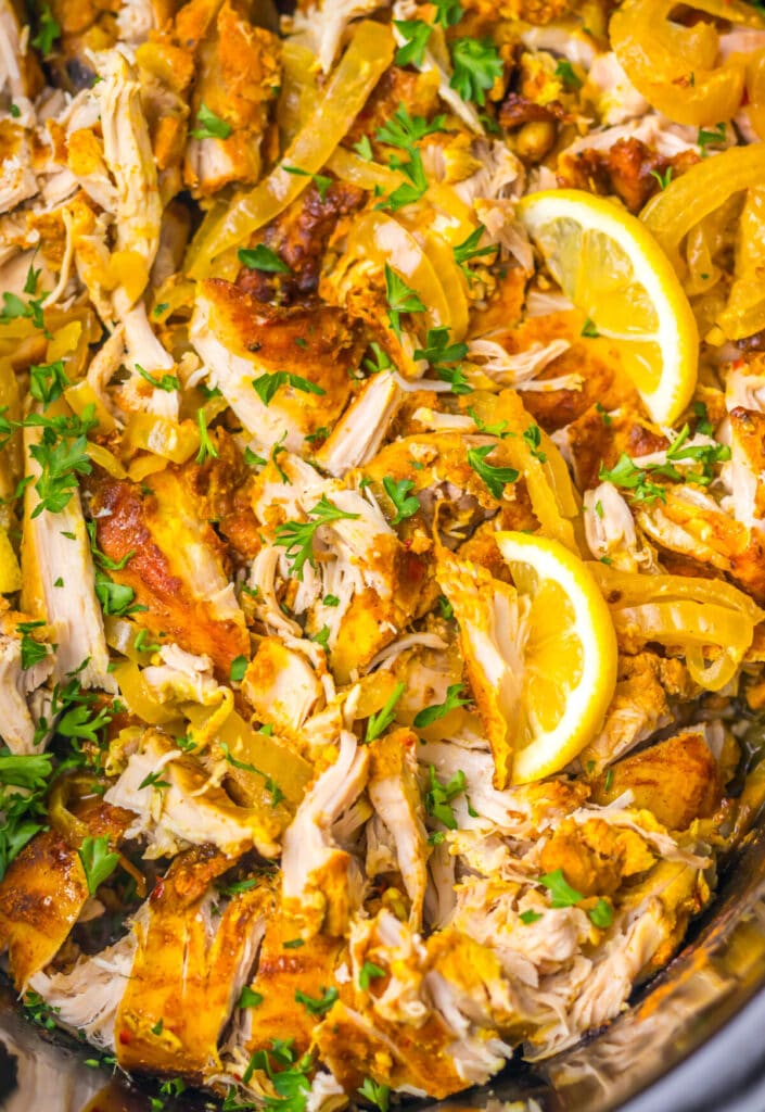 Close-up of slow cooker chicken shawarma simmering with lemon slices and warm spices