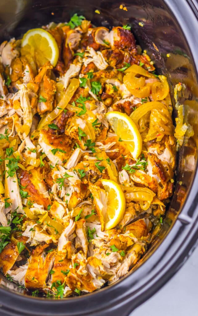 Close-up of slow cooker chicken shawarma simmering with lemon slices and warm spices