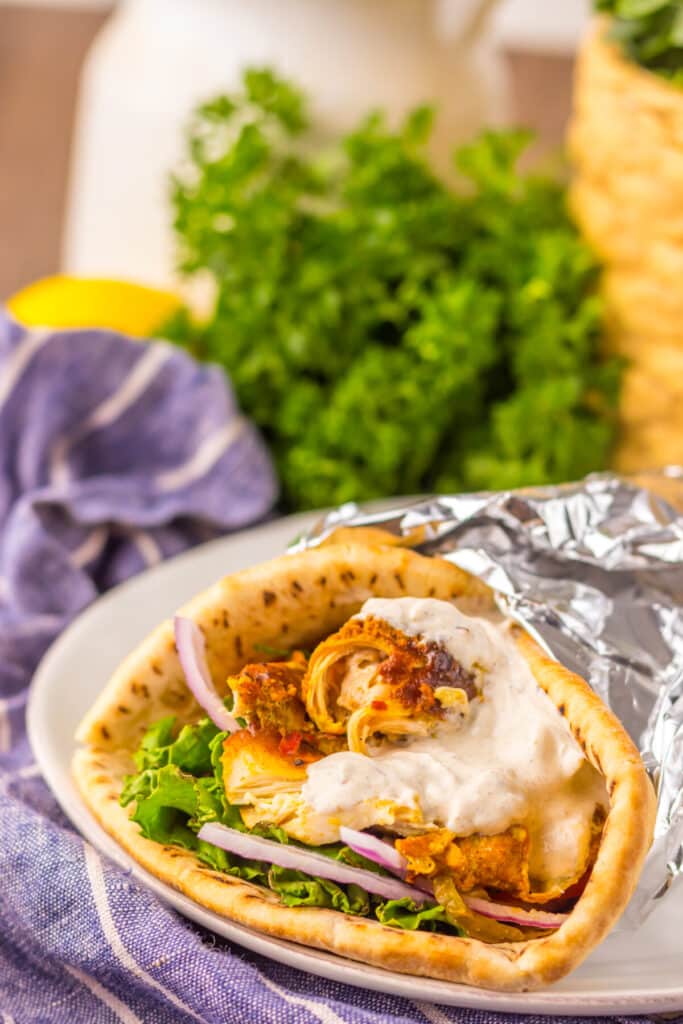 Slow Cooker Chicken Shawarma in pita with lettuce, tomato, and yogurt sauce
