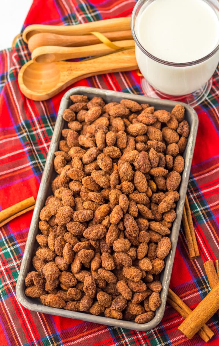 Overhead shot of cinnamon almonds on plaid napkin cooling.