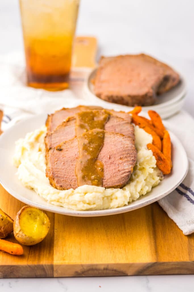 Thin slices of eye of round roast served with mashed potatoes and brown gravy.