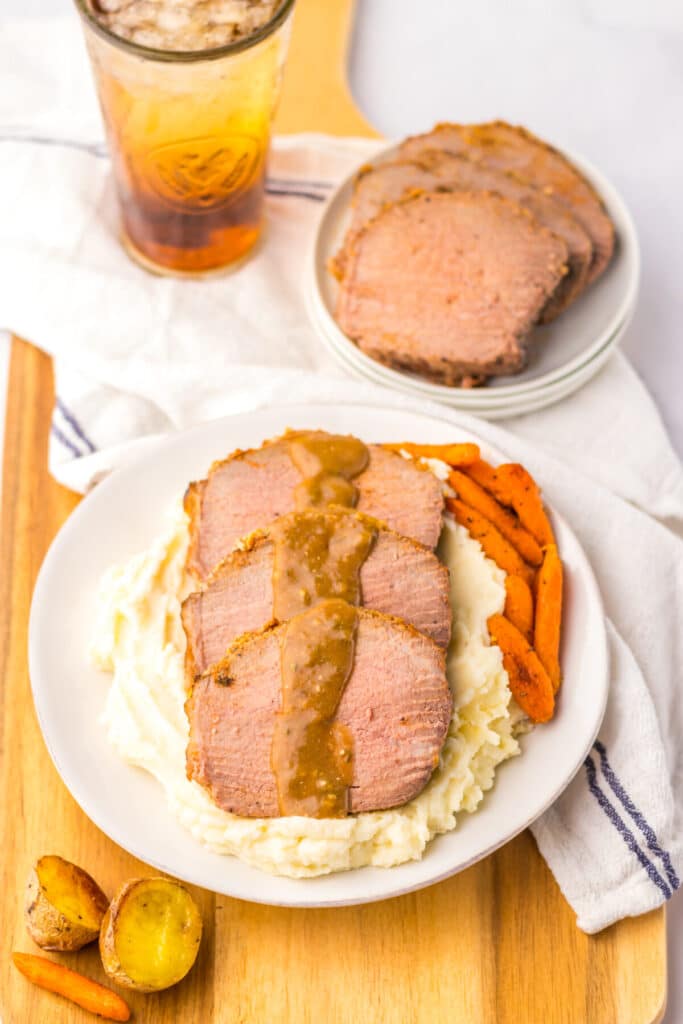 Thin slices of eye of round roast served with mashed potatoes and brown gravy.
