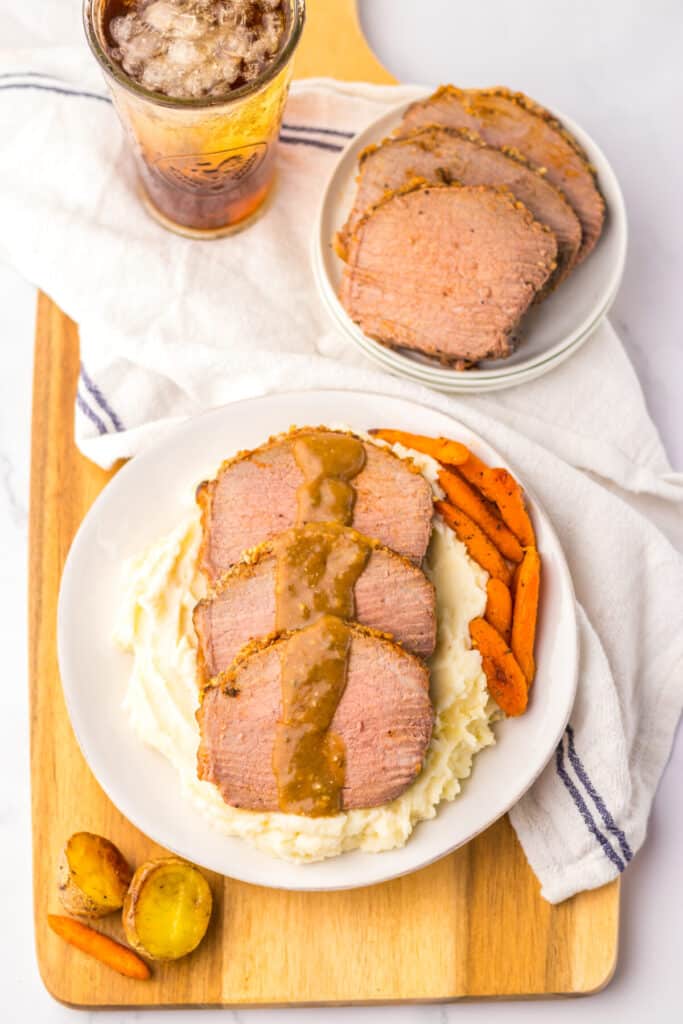 Thin slices of eye of round roast served with mashed potatoes and brown gravy.