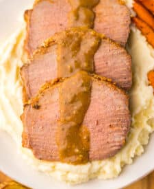 Thin slices of eye of round roast served with mashed potatoes and brown gravy.
